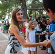 2017年8月，西班牙國王一家在西班牙島嶼度假，圖為西班牙王后萊蒂西亞（左）與兩名女兒與群眾握手。（法新社）