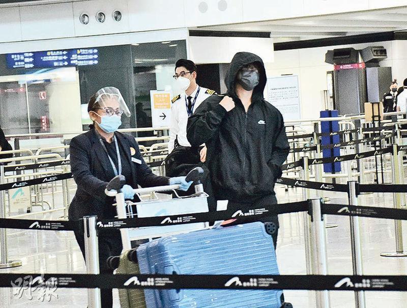 姜濤（右）包到冚步出香港機場，有機場人員幫他推行李車。（攝影：鍾偉茵）
