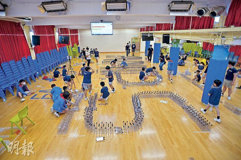 砌出「AMPS」——經過2小時的不斷嘗試，同學們用2010個長方形膠水樽，砌出「AMPS」字樣，並準備挑戰健力士世界紀錄。（黃志東攝）