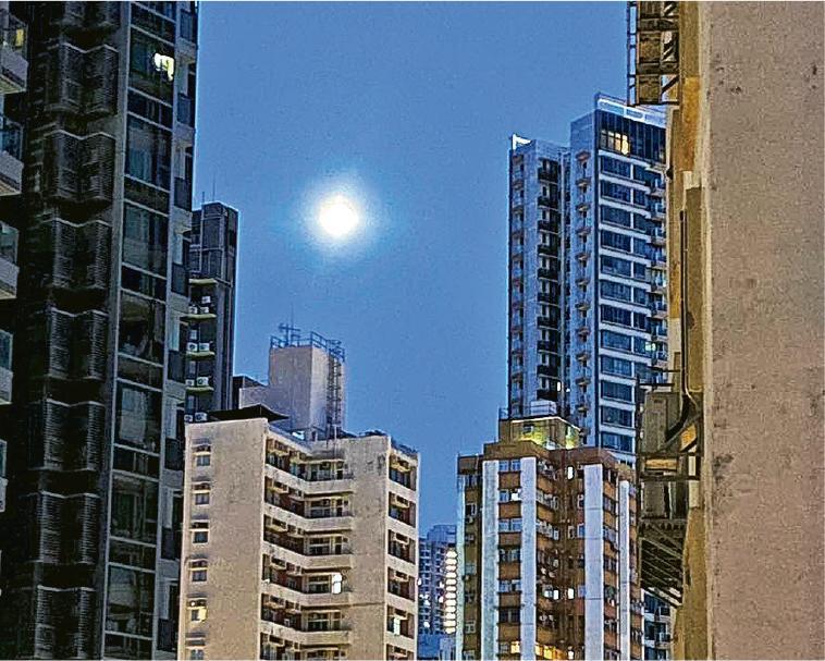 梁詠詩有天在早上5時55分起牀望窗，見到滿月高掛在南安街上方，出帖文後引來眾街坊分享「窗邊月亮」。（受訪者提供）
