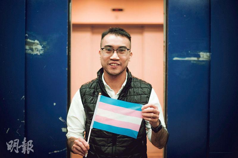Henry手上小旗是代表跨性別人士的旗幟，粉藍代表男寶寶，粉紅是女寶寶，中間白色是代表正在經歷性別過渡或性別中立的一群。（鍾林枝攝）