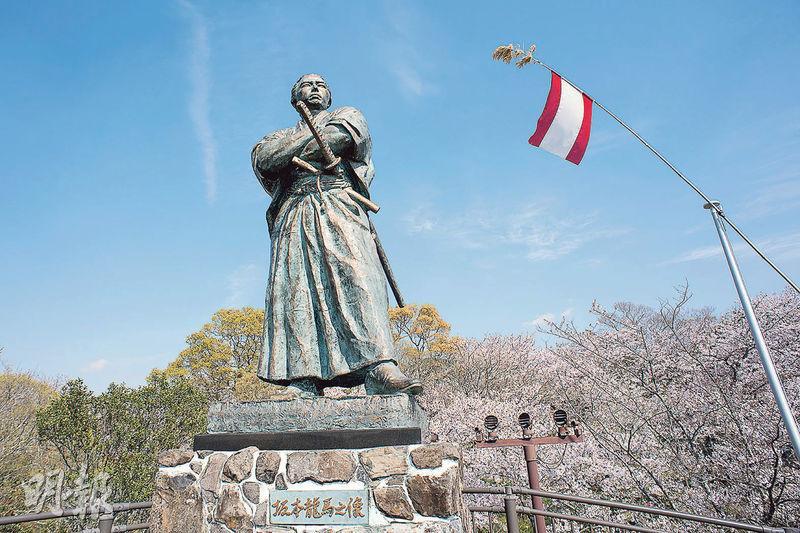 坂本龍馬像——坂本龍馬像在春天被櫻花環抱，英氣的雕像頓時帶點浪漫。（卓文慧攝）