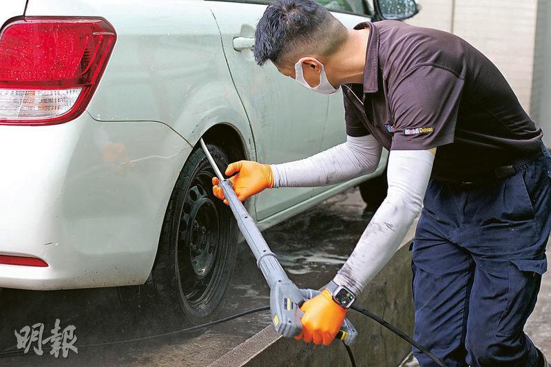 人手洗車--人手洗車較仔細，清潔員工會深入清理車輪旁邊的凹槽及沙板暗藏的沙石碎片。（周群雄攝）