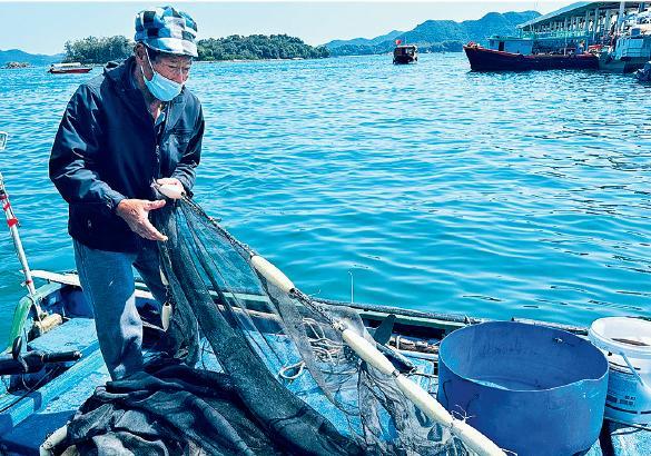 老漁民富興叔使用傳統罟網捕魚技藝。（受訪者提供）