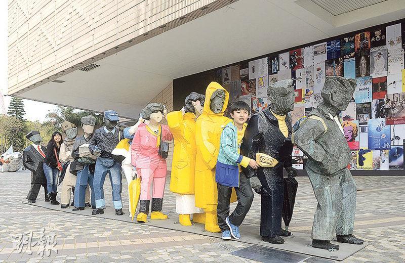 尖沙嘴文化中心外的人間系列《排隊》為2002年製成的青銅鑄模，人物尺寸跟真人相若，每個人身上附以不同配件。（資料圖片）