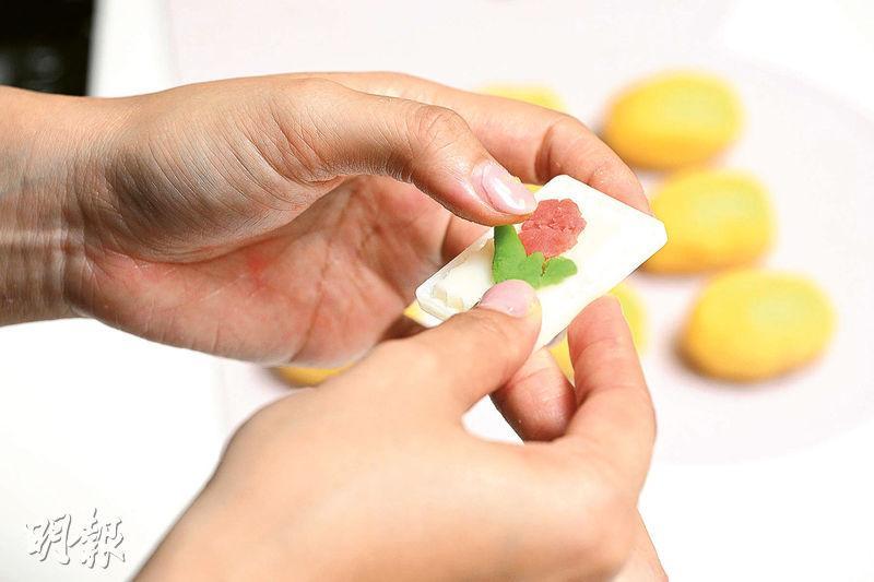 製作技巧——壓在模片花朵位置的麵糰做厚一點，這會較容易黏住黃色麵糰皮。（曾憲宗攝）
