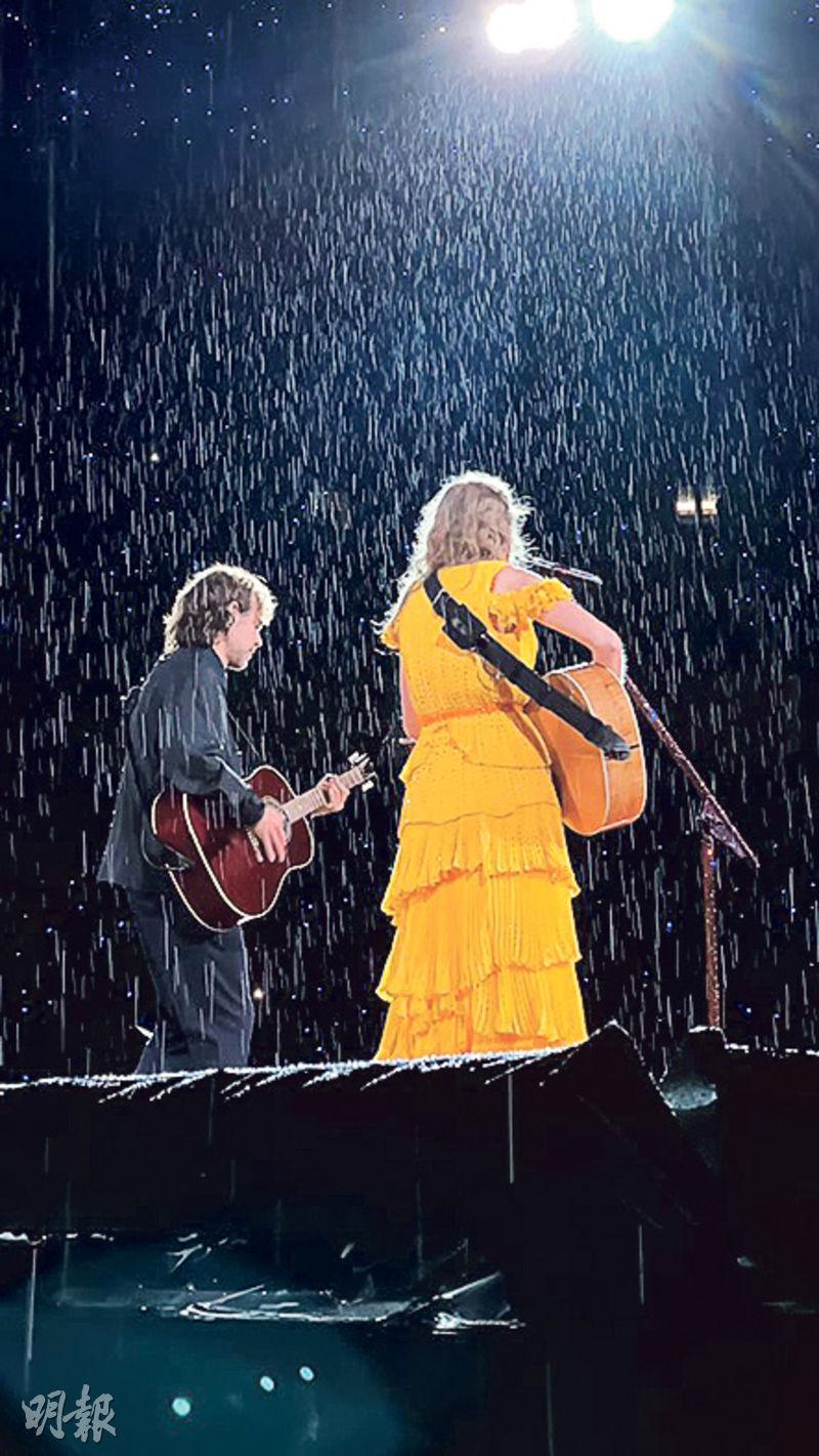 Taylor Swift（右）跟拍檔Aaron Dessner（左）冒雨演出。（網上圖片）