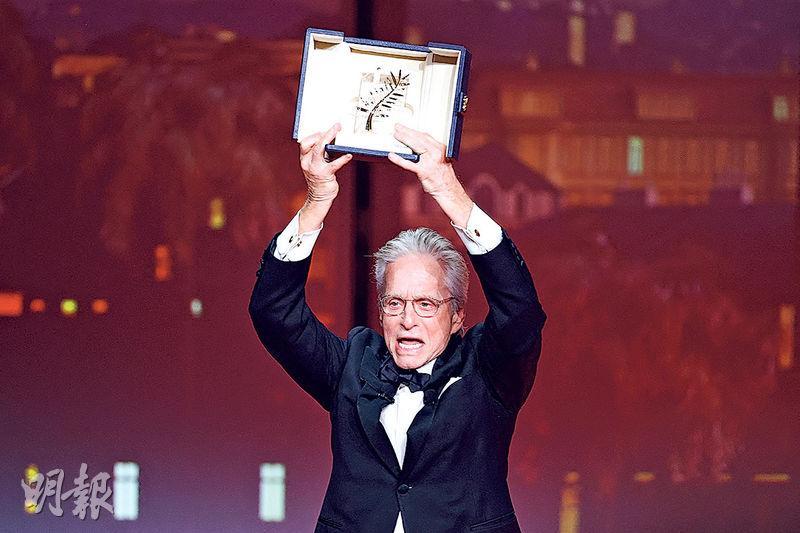 米高德格拉斯在開幕禮獲頒榮譽金棕櫚，興奮得高舉獎座。（路透社）