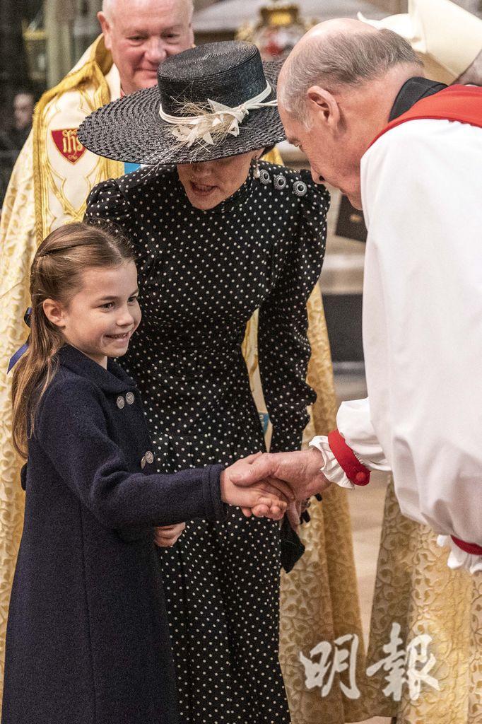 2022年3月29日，夏洛特小公主出席已故菲臘親王悼念活動，面露笑容與大主教握手。（法新社）