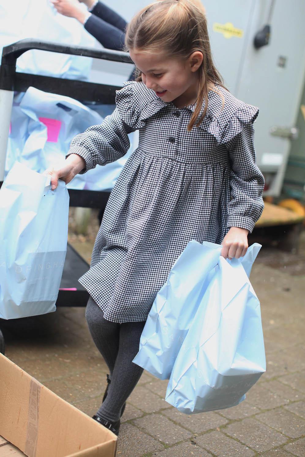 肯辛頓宮發放夏洛特小公主的近照，紀念她5歲生日。圖為她派發食物給隔離中的居民。（肯辛頓宮Twitter圖片）