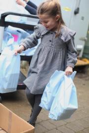 肯辛頓宮發放夏洛特小公主的近照，紀念她5歲生日。圖為她派發食物給隔離中的居民。（肯辛頓宮Twitter圖片）