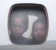 喬治小王子 (左) 與夏洛特小公主 (右) 從飛機窗口向外望。（法新社）