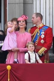 凱特（左二）抱着夏洛特小公主，喬治小王子（左三）則站在威廉王子前，露出有趣表情。（法新社）