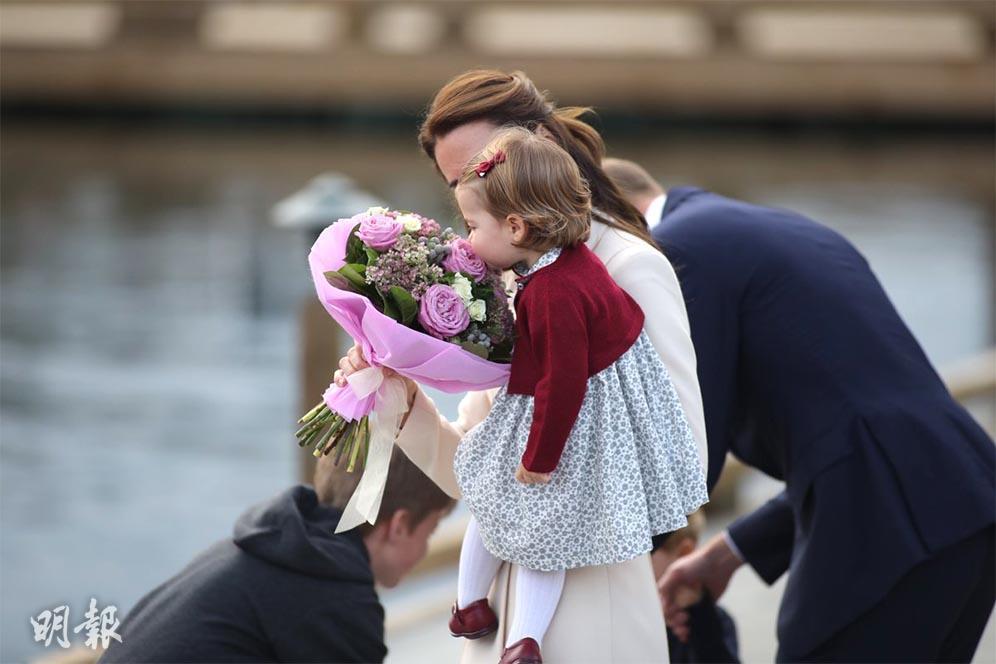 【英王室結束訪加】凱特讓懷中的夏洛特小公主聞聞花香。（The Crown in Canada Twitter圖片）