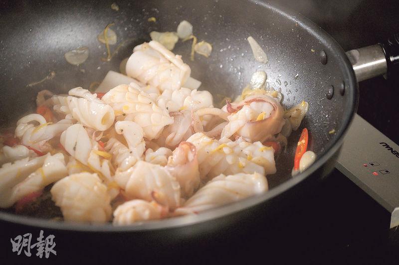蜷曲熟透--當魷魚炒至蜷曲和熟透時，表示已吸收了鹹酸菜和辣椒的味道，這時便可以加入唐芹。（蘇智鑫攝）