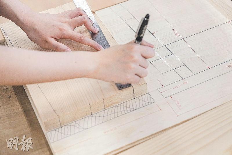 在木料上標記好要裁切線條的兩端，之後再用直線連起，就可隔着實木木板複印裁切線條。（馮凱鍵攝）