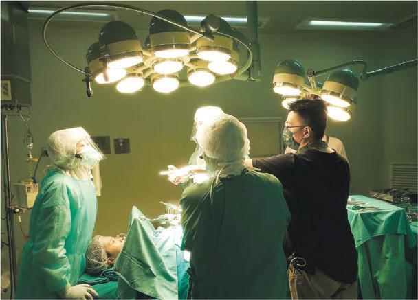 場面逼真——台灣導演林君陽（黑衣者）執導的《疫起》取材自2003年SARS期間台北市立和平醫院封院事件，電影中不乏極為逼真的手術場面，講述醫護冒着疫症風險為病人施行手術。（電影公司提供）