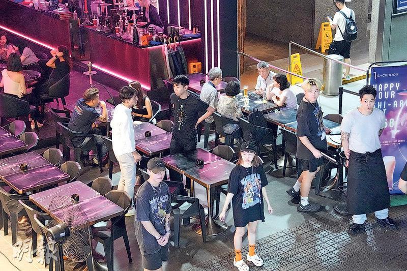 暑假周四晚上，8時後的尖沙嘴諾士佛臺人流不多，圖中酒吧只有約四成客滿，酒吧出動至少4名職員在門口「拉客」。（資料圖片）
