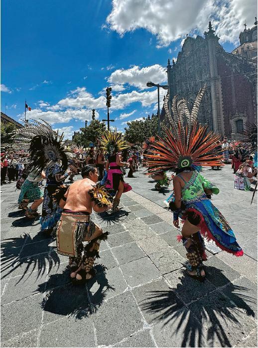 在墨西哥城市中心的憲法廣場，不時見到穿著阿茲特克民俗服的舞者，在天主教堂前跳着傳統舞蹈，展現古文明與殖民文化的融合。（洪慧冰攝）