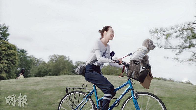 張曼玉束起頭髮載着愛犬騎單車，非常寫意。