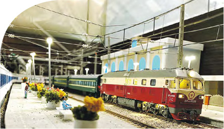 Henry第一個火車模型情景藏在舊居客廳地台中，有配合比例的月台、花盆及行人，從低角度拍攝，很有置身火車站月台的感覺。（受訪者提供）