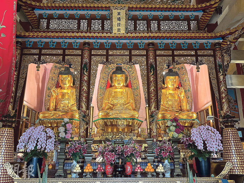 三寶佛像分別是阿彌陀佛（左起）、釋迦牟尼佛、藥師佛，每尊都髹上金漆，在以深啡色為主色調的大殿中特別搶眼。（周群雄攝）