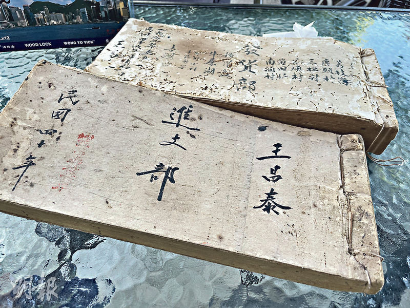 「王昌泰穀米」1951年「進支部」（下）和1957年「發貨部」（上）的帳簿，記錄了向「王昌泰」買米的村落。（姚超雯攝）