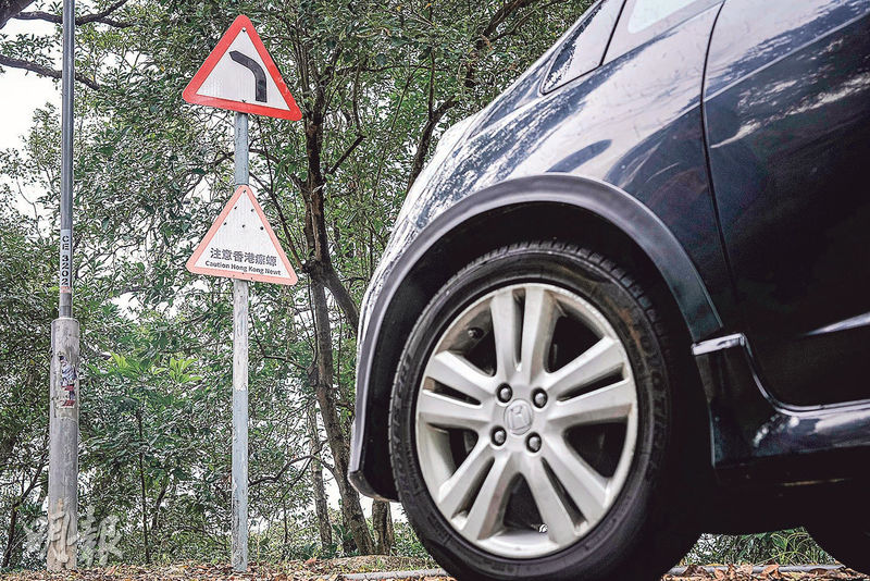 飛鵝山道雖現有「注意香港瘰螈」提示牌，但駕駛者難用肉眼發現路面的細小生物。（馮凱鍵攝）