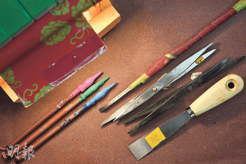 張誠忠說現時用的手雕工具跟以往一樣，由左至右為暖牌燈箱、上色筆、雕刀、索子及白板刮刀、一筒刮刀及油漆鏟。（曾憲宗攝）