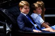 2022年6月2日，英國路易小王子（中）跟哥哥喬治（左）、姊姊夏洛特（右）一起坐馬車。（法新社）