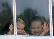 2019年6月8日，英女王伊利沙伯二世93歲官方壽辰閱兵巡遊慶祝活動在白金漢宮舉行，夏洛特小公主（左）和路易小王子（右）未出陽台前，在窗前好奇外望及揮手。（法新社）