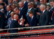 2024年5月25日，英國喬治小王子（前排右二）跟爸爸王儲威廉（前排右三）在溫布萊球場觀看英格蘭足總盃決賽曼聯戰曼城。圖為曼聯領隊坦夏格與喬治小王子握手。（路透社）