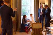 喬治小王子（中）騎在木馬上與媽媽凱特（右四）聊天。（The British Monarchy facebook圖片）