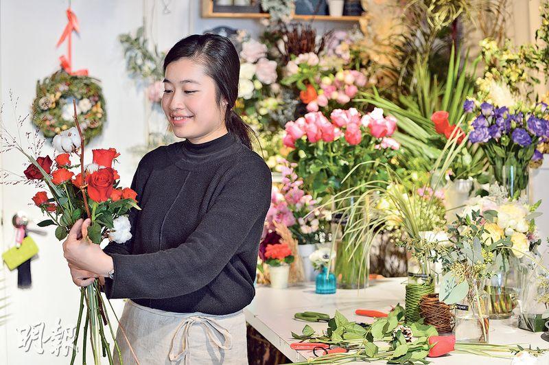 Ｍiranda（圖）製作手上花束時，用上大小不一的紅玫瑰和近年韓國十分流行的棉花。她計劃年宵時推出劍蘭、百合等傳統年花，將加入花藝元素，創造出不失傳統，但讓人耳目一新的花束。（鄧宗弘攝）