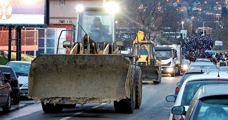 科索沃的塞爾維亞族人上周六出動泥頭車等汽車，堵塞北米特羅維察一條村莊附近的道路。（路透社）