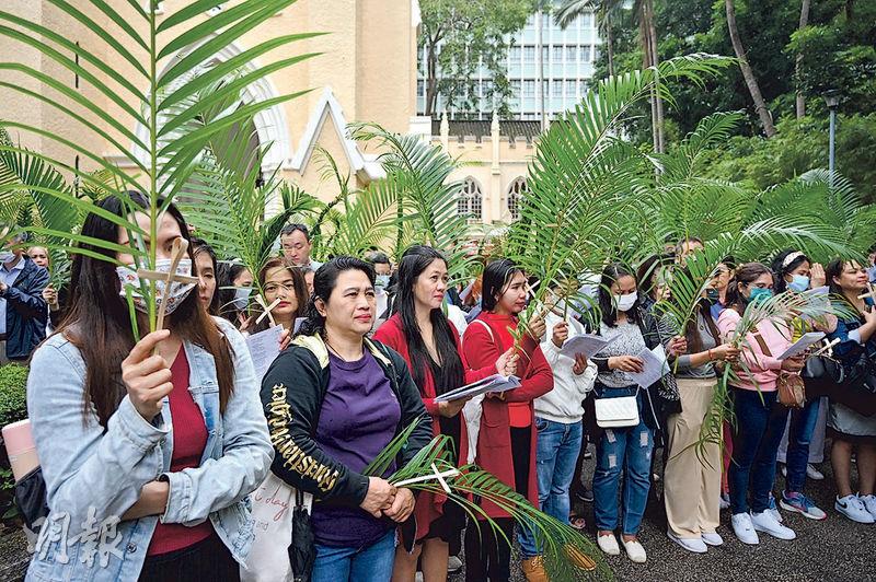 昨早9時許約300名教徒出席中環花園道聖約翰座堂「棕枝主日之宗教慶典」，當中不少參加者均戴上口罩。大部分人手持棕枝，在場亦有軍裝警在馬路口維持秩序。（鄧宗弘攝）