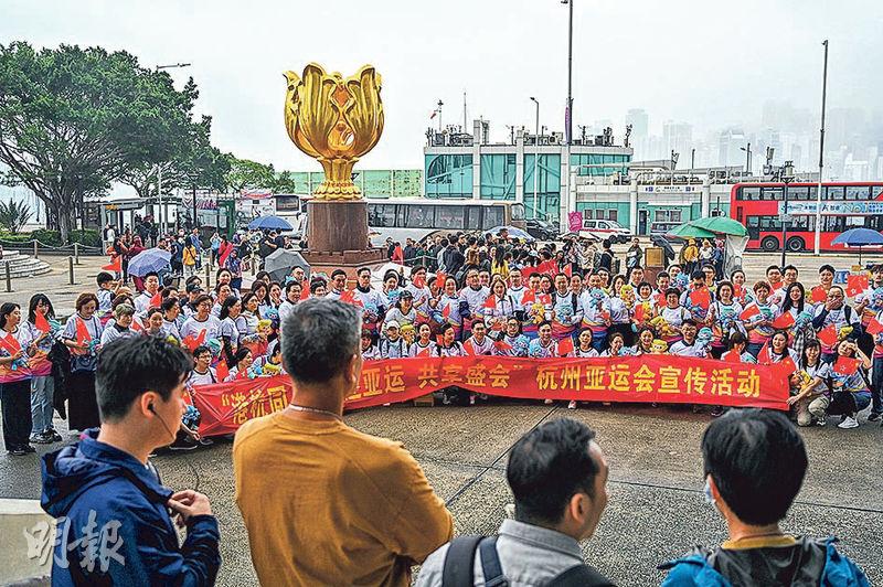 杭州旅港同鄉會昨在灣仔金紫荊廣場舉行「喜迎杭州第19屆亞運會」遊行集會，眾人手持國旗及區旗影大合照，其間有便衣警員在場拍照和協調。不反對通知書列明主辦方須確保所有人穿著大會T恤及貼有識別貼紙。（鄧宗弘攝）