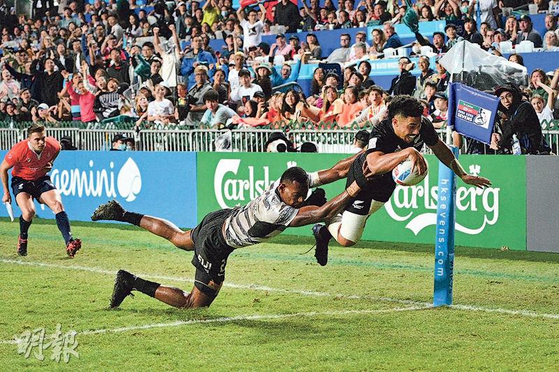 香港國際七人欖球賽昨日煞科，男子組決賽由斐濟對新西蘭，斐濟隊的Joseva Talacolo（中）飛身攔截，但新西蘭隊的Ngarohi McGarvey-Black（右）仍成功達陣，最終新西蘭以24︰17挫斐濟奪魁。（朱安妮攝）