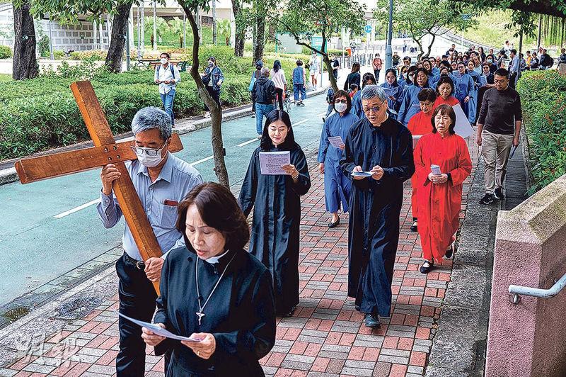 聖公會聖腓力堂昨約100人參與「行苦路」宗教遊行，在隊前扶十字架，一邊唱聖詩，是昨日唯一遊行不反對通知書無《禁蒙面法》要求。據本報點算，遊行期間有30名參與者戴口罩，佔總數約三成。（朱安妮攝）