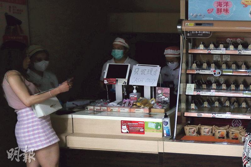 港鐵香港站昨午約12時起停電，逾20店舖受影響，包括餐飲店舖（圖）、書店等，至下午約1時許店舖電力供應才陸續恢復。圖中店舖貼出「只收現金」提示。（李紹昌攝）