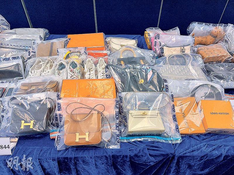 警方在案中檢獲一批名牌手袋，包括最貴的一款、圖中第一排中間的白色Hermes手袋，價值20萬元。（孫華中攝）