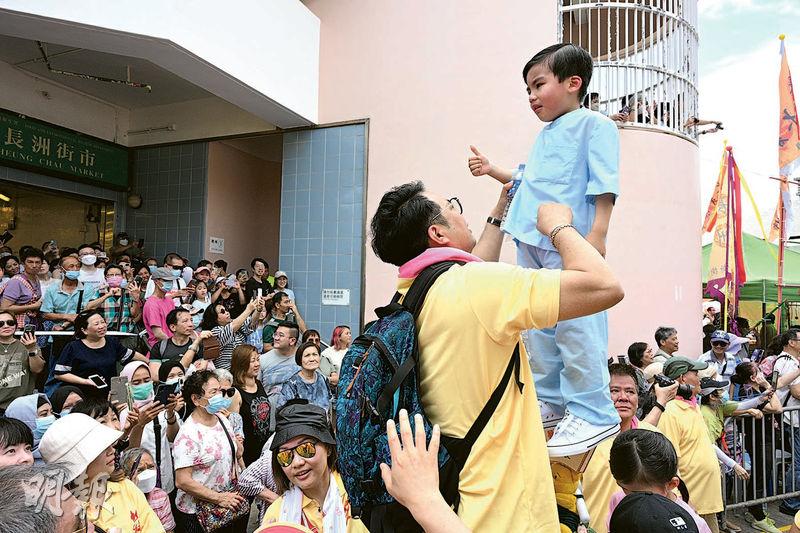 有小童扮演醫護人員致敬，其中身穿粉藍色醫護套裝的男童途中一度哭起來，在旁市民大叫「加油」。家長為他拭淚後，小童重現笑容。（曾憲宗攝）