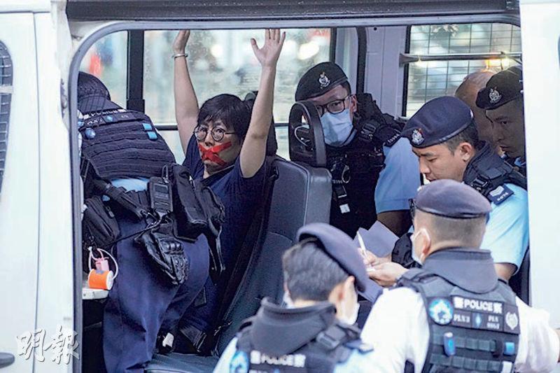 兩人以紅色膠紙封嘴，天安門母親運動成員劉家儀被帶上警車時舉高雙手，沒反抗或作聲。（楊柏賢攝）