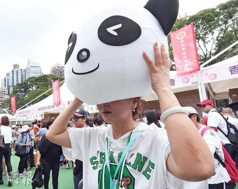 香港四川社團總會的攤位有售「國寶」熊貓公仔，攤位工作人員戴上熊貓頭套宣傳。（李紹昌攝）