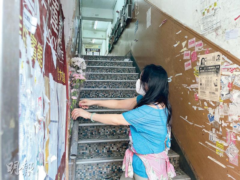 倫常命案翌日，有市民在事發唐樓梯間放置花束，向3名遇害女孩致意。（杜沛妍攝）