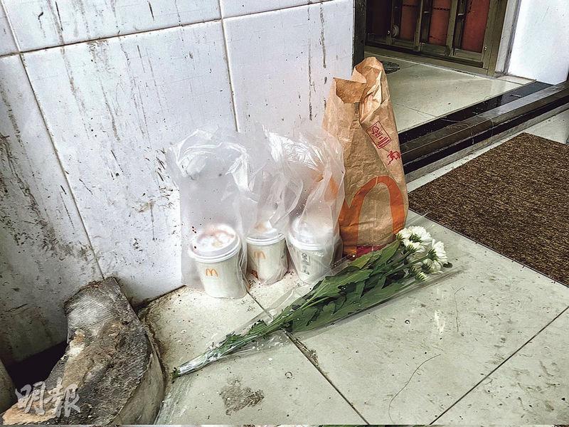 案發單位門外亦有人放下3份一般小孩子愛吃的連鎖快餐店食品及一束鮮花。(杜沛妍攝)