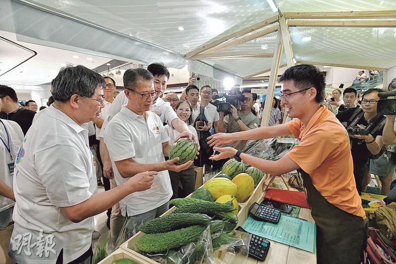 財政司長陳茂波（前左二）出席「西瓜節」開幕禮後購買場內本地農產品，包括價值280元的美鈴西瓜（圖）。（楊柏賢攝）