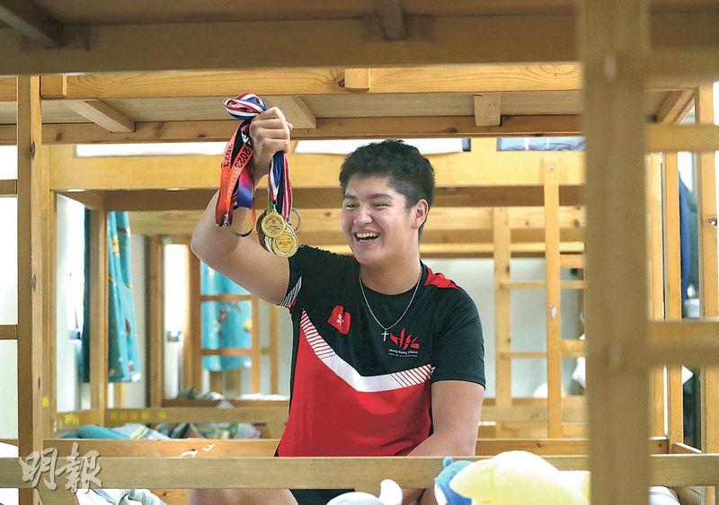 阿穆跟記者數着自己獲得的獎牌，說希望年底出戰亞洲青少年賽艇錦標賽。他笑說：「聽講有啲選手食蟲，所以咁大隻，我有啲驚。」（李紹昌攝）