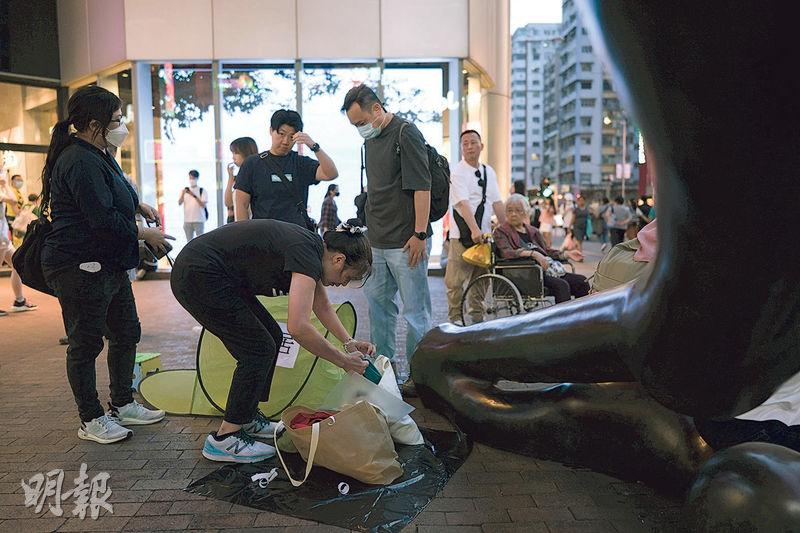 社運人士「女長毛」雷玉蓮昨晚7時許在旺角朗豪坊外築起露營帳篷，上面貼有「蝸居」二字，其後蜷縮在內，表達港人住宿生活困難，其間約3名便衣警員上前問話，並搜查其隨身物品，包括關於末代港督彭定康的書。雷隨後獲准在少於一小時內表達訴求，10多名警員在附近圍繞監視。（鄧家烜攝）