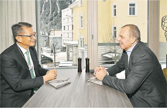 財政司長陳茂波（左）過去一年出訪7次。圖為他今年1月到瑞士達沃斯出席世界經濟論壇年會，連同5名隨行人員離港8天，開支共89.8萬元。（政府新聞處資料圖片）